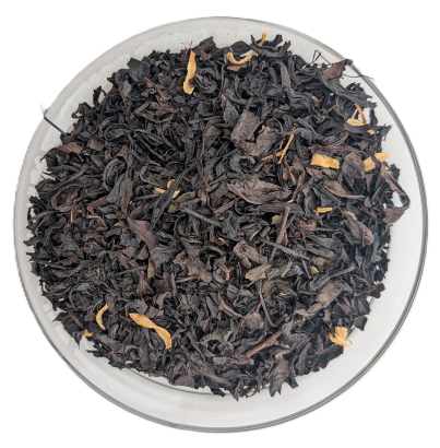 Dunkle Oolong-Teeblätter gemischt mit gelb-orangefarbenen Orangenblütenblättern in einer Schale.
