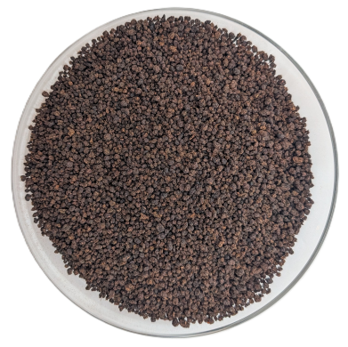 Draufsicht auf dunkelbraunen Bio-Assam-Schwarztee in kügelchenförmiger CTC-Grobkörnung in einer Schale.