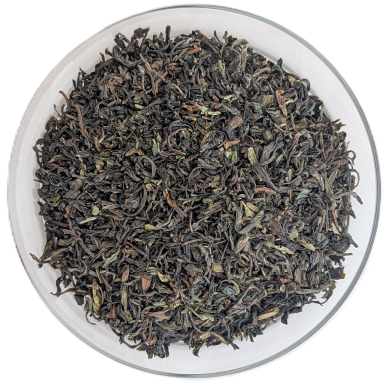 Draufsicht auf First Flush Bio-Darjeeling Singell mit einer Mischung aus grünlichen und dunklen Teeblättern.