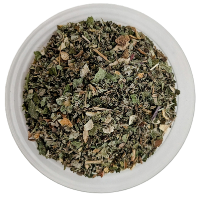 Draufsicht auf eine runde Glasschale mit losem Tee. Die Mischung besteht überwiegend aus grob zerkleinerten, dunkelgrünen und graugrünen Kräuterblättern. Dazwischen sind schmale, holzige Stängelstücke, kleine orangefarbene Schalenfragmente sowie feine, ge