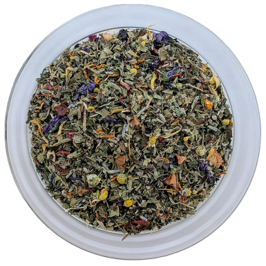Draufsicht auf eine runde Glasschale mit losem Kräutertee. Die Basis bildet eine feine Mischung aus mattgrünen, getrockneten Blättern. Darunter sind auffällige, dunkelviolette Malvenblüten, zarte lila Lavendelblüten und kleine, leuchtend gelbe Ringelblume