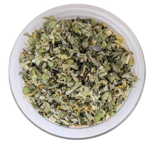 Draufsicht auf eine Glasschale mit geschnittenem Bio-Griechischen Bergtee, gemischt mit gelben Blüten und feinen Orangenschalenstücken.