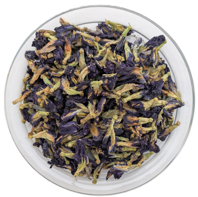 Getrocknete, blau-violette Schmetterlingsblüten (Butterfly Pea Flowers) mit grünen Stängeln in einer durchsichtigen Glas-Schale auf weißem Hintergrund.