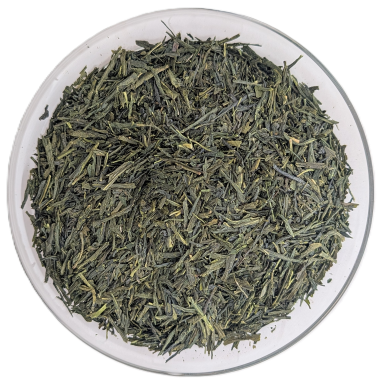 Nadel-förmige, sattgrüne Bio-Sencha-Uji-Teeblätter in einer Glasschale auf weißem Hintergrund.
