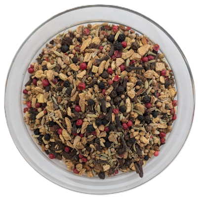 Gewürztee Ayurveda Chai in einer klaren Schale, reich an hellen Ingwerstücken, roten Pfefferkörnern, Anissamen und Nelken.