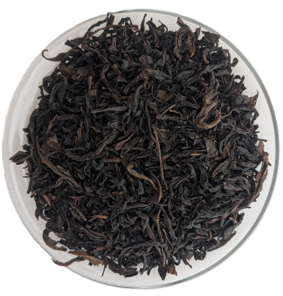 Offene, dunkelbraune und leicht gedrehte Da Hong Pao Oolong-Teeblätter aus China in einer Glasschale.