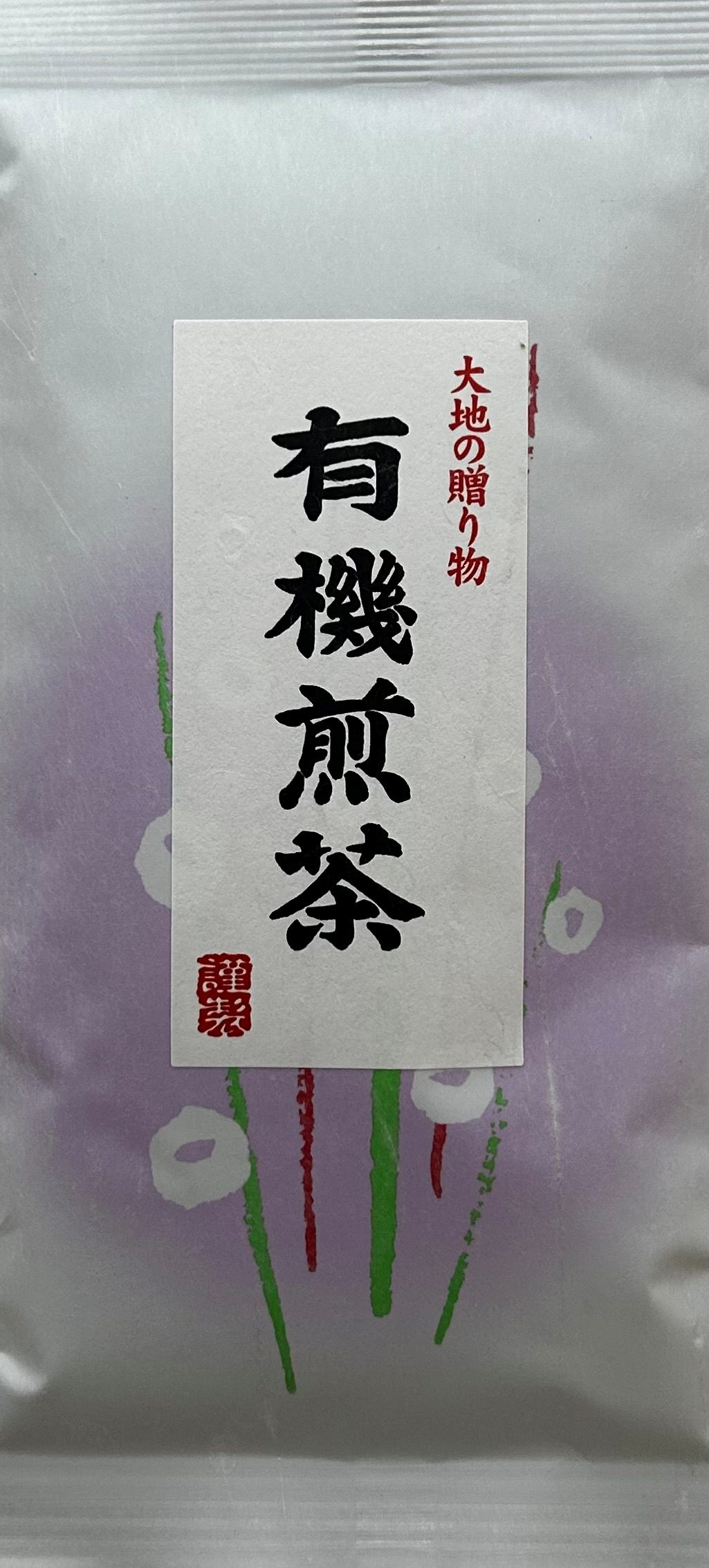 Elegante, weiße Washi-Papier-Verpackung, die im Hintergrund mit einem zarten, pastell-lilafarbenen Muster aus abstrakten, geometrischen Blütenformen bedruckt ist. Auf der Vorderseite ist ein großes, weißes Papier-Etikett aufgeklebt, das von einer kraftvol