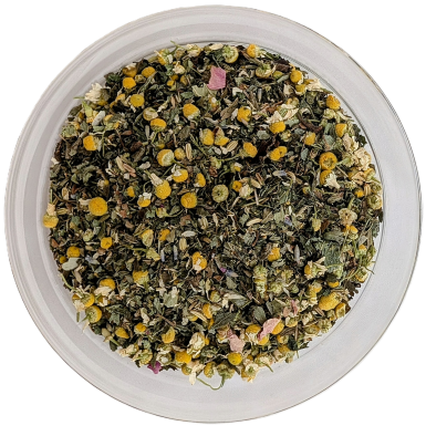 Eine kreisrunde Glasschale aus der Vogelperspektive, gefüllt mit einer losen Kräuterteemischung. Zu sehen sind getrocknete, grüne Blätter, gelb-weiße Kamillenblüten und vereinzelte rosa Blütenblätter.