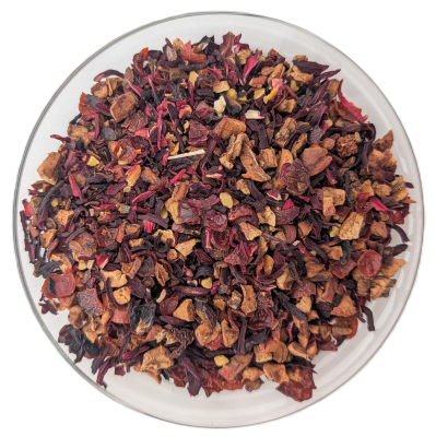 Früchteteemischung aus Hibiskusblüten, Apfelstücken und Zimtstücken in einer Glasschale.