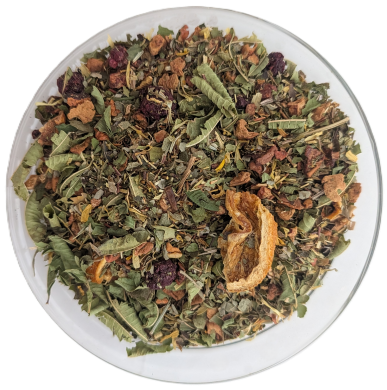 Draufsicht auf die Teemischung Kräuter und Beeren in einer Glasschale, bestehend aus groben grünen Blättern, getrockneten Beerenstücken und einem großen orangefarbenen Fruchtstück.