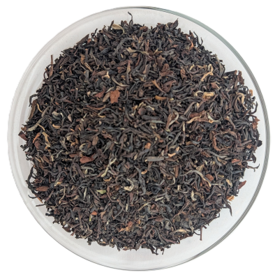 Darjeeling Second Flush Margaret's Hope – feines, gedrehtes Teeblatt in Braun- und Grüntönen in einer gläsernen Schale.