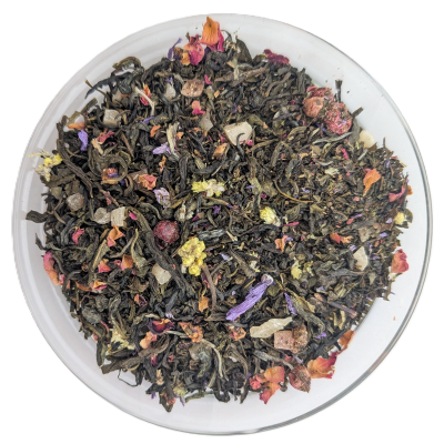 Bunte Grünteemischung mit roten Beeren, rosa Blüten und hellen Fruchtwürfeln in einer Glasschale.