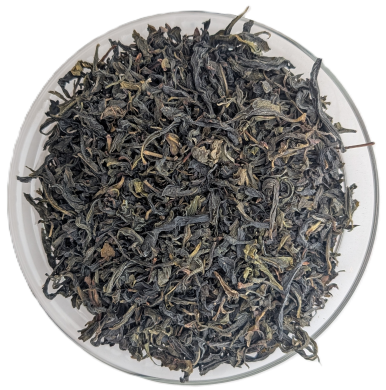 Bio Pouchong Grüner Oolong mit getrockneten, länglichen, olivgrünen Teeblättern in einer Schale.